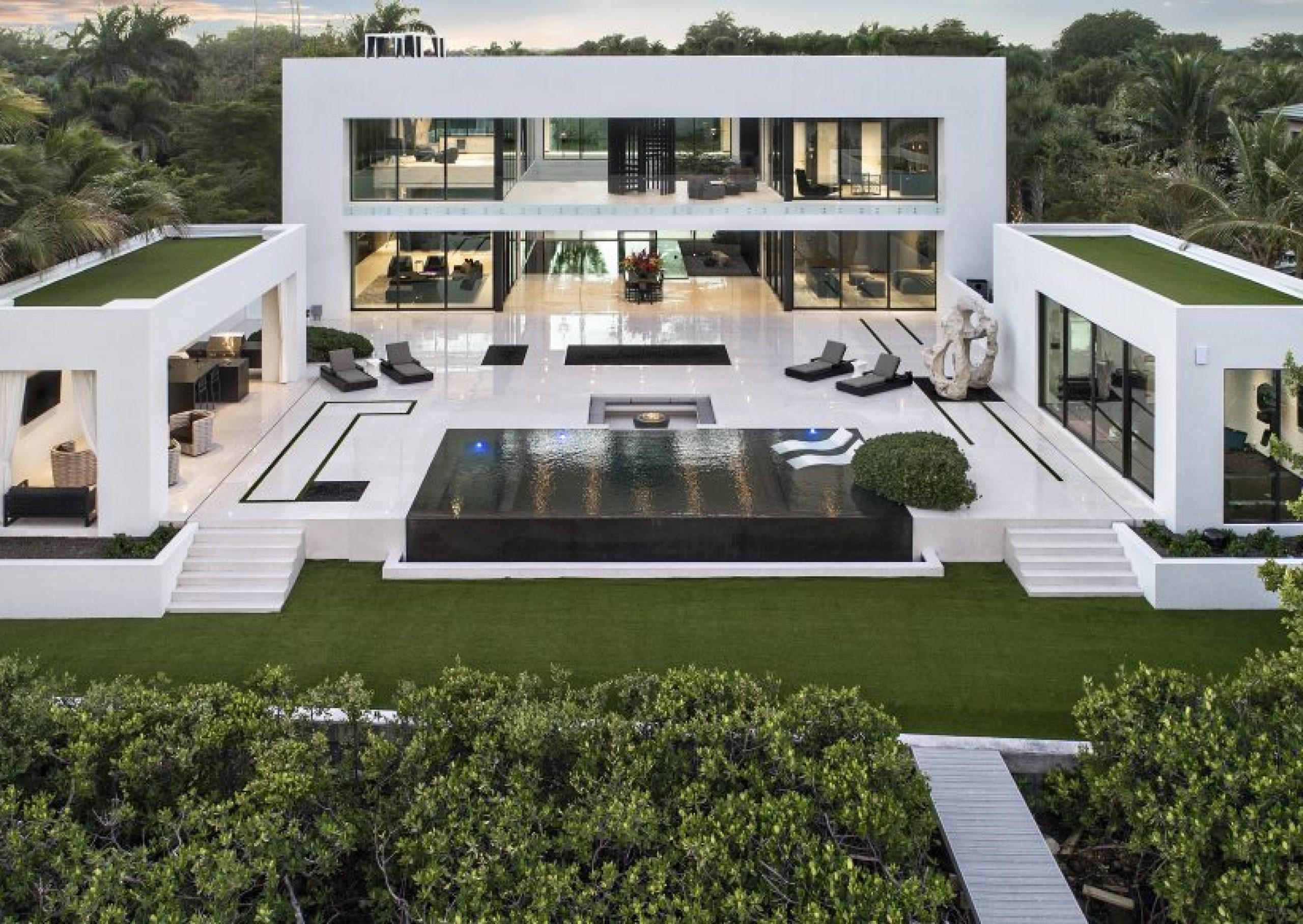 A symmetrical, courtyard-driven residence centered around a strong architectural axis and expansive outdoor living space. Defined by clean volumes, reflective surfaces, and a restrained palette, the home is executed with precision to create a balanced and immersive living environment.